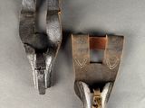 deux morceaux de cuir sont fixés à l'arrière d'une paire de chaussures