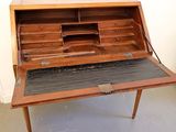an old wooden desk with a black top and drawers