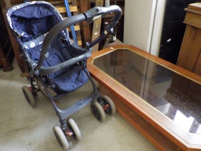 a baby stroller sitting next to a coffee table in a room