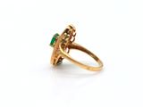 a gold ring with an emerald stone in the center
