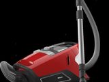 a red vacuum cleaner with a black handle on a black background