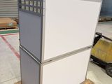 a white refrigerator sitting on a pallet in a warehouse