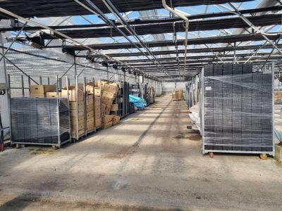 une grande serre remplie de caisses et de palettes