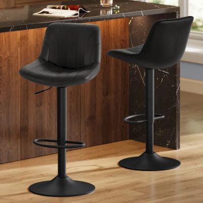 Deux tabourets de bar en cuir noir sont disposés devant le comptoir de la cuisine.