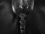 black and white photograph of a wine glass sitting on a leather couch