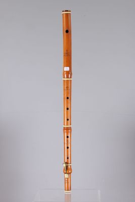 a wooden flute on a clear surface with a gray background
