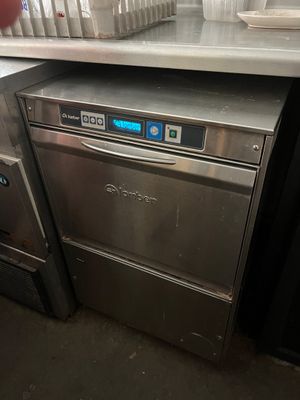 a silver dishwasher sitting on a counter in a kitchen