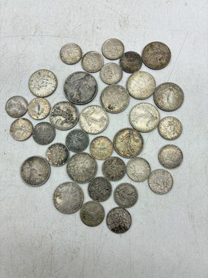 une pile de pièces d'argent posée sur une surface blanche