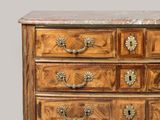 a wooden chest of drawers with a marble top