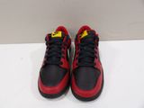 pair of red and black sneakers on a white surface