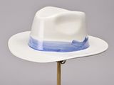 a white hat with a blue band on a gold stand
