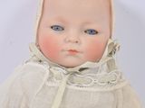 a small doll with a bonnet on it ' s head