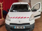 une camionnette blanche avec une bande rouge garée dans un garage