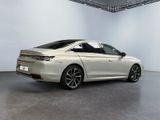 the rear end of a silver car in a white room