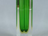 a green vase that is sitting on a white surface