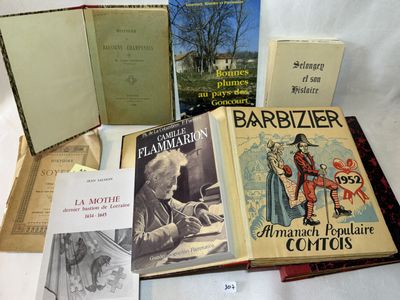 Plusieurs livres sont posés sur une table recouverte d'une nappe blanche.