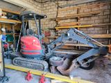 une photo d'une petite pelleteuse dans un garage