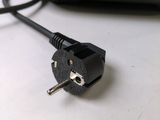 a black power cord plugged into a laptop computer