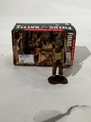 un petit soldat en bois qui se tient à côté d'une boîte
