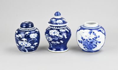 three blue and white vases with flowers on them sitting on a table