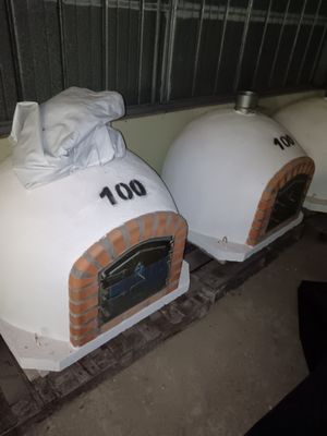 two pizza ovens sitting next to each other on the floor