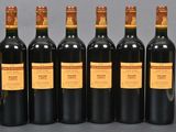 six bottles of wine are lined up in a row on a table