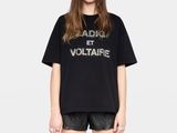 une femme portant un t-shirt noir avec un slogan imprimé dessus