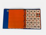 an open book with a bunch of coins in it on a white surface