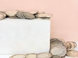 a white marble block with a pile of coins on top of it