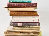 many books stacked on top of each other on a table