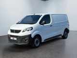La petite camionnette blanche est garée dans une grande pièce.