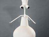 a white vase on a pedestal with two eyes on it