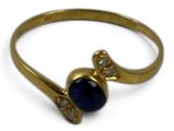 a close up of a gold ring with a blue stone on it