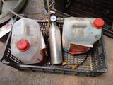 two plastic jugs sitting in a basket next to a gas can