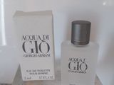 un flacon d'Acqua di Gio posé sur une table, à côté d'une boîte