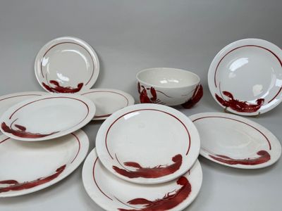 beaucoup d'assiettes et de bols blancs et rouges sur la table