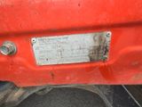 a close up of a metal plate on the back of a red truck