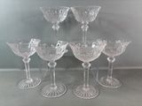 six verres à vin transparents posés sur une table