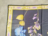 a blue and yellow scarf with flowers and leaves on it