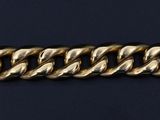 a close up of a gold chain bracelet on a black background