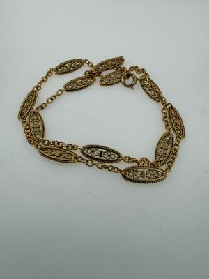 a gold chain bracelet with a leaf design