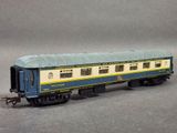 the blue and yellow train car is sitting on a gray surface