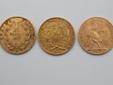 three different types of gold coins on a white surface
