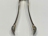 a small metal object on a table with a white background