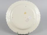 underside view of a white plate with a scalloped edge