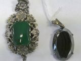 two pieces of jewelry that are sitting on a table