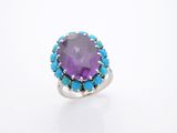 un gros plan d'une bague ornée d'une pierre violette entourée de pierres turquoise