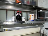 a kitchen with a lot of counter space and a microwave on the wall