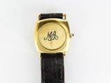 un gros plan d'une montre-bracelet portant un monogramme