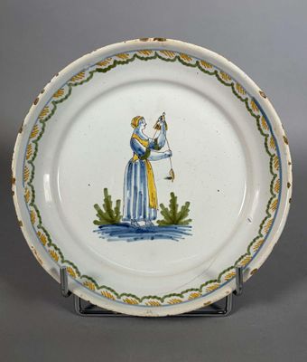 une assiette sur laquelle est représentée une femme tenant un oiseau